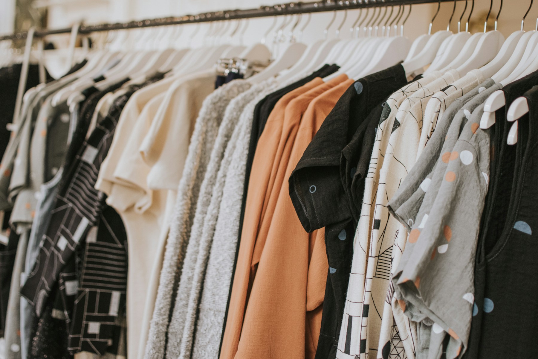A rail of clothing in soft neutral colors